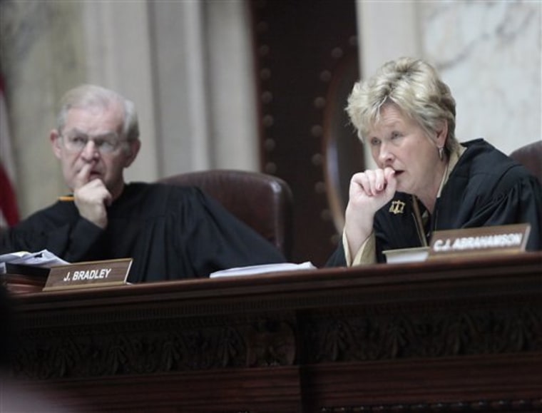 Wisconsin Supreme Court Justices David T. Prosser, Jr., and Ann Walsh Bradley consider oral arguments during a hearing regarding the state's budget bill at the Wisconsin State Capitol, in June.